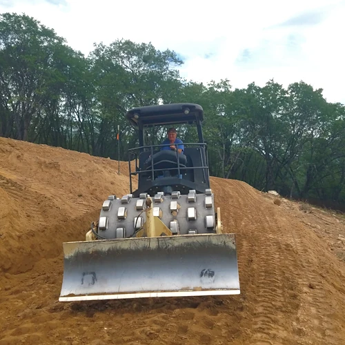 A sheepsfoot compactor penetrates loose ground to knead and compress cohesive soils